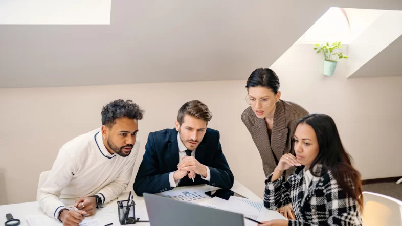 Professional team reviewing nonprofit formation paperwork and bylaws during modern office board meeting