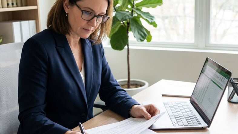 A professional registered agent reviewing nonprofit compliance documents in a modern office.